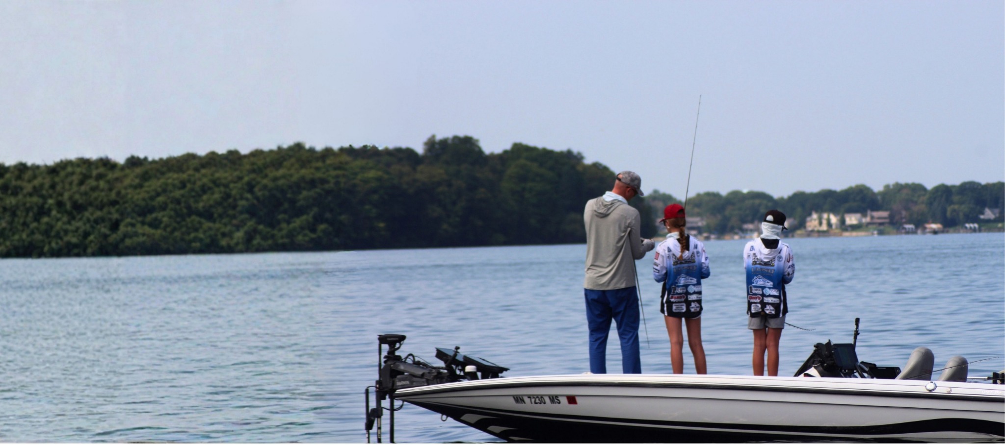 Matt coaching Cora alongside another student angler on the boat